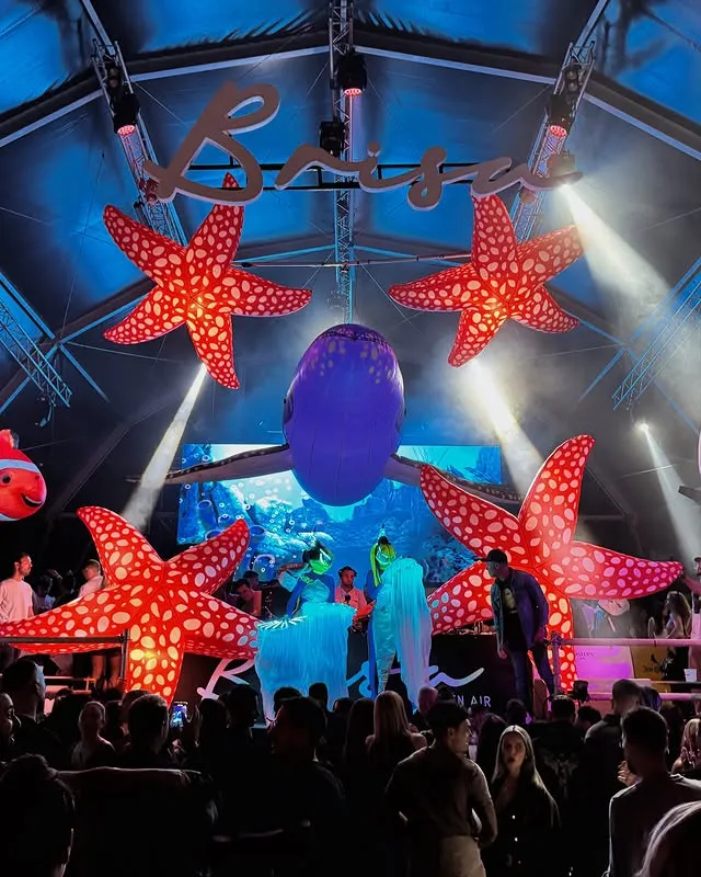 Carpa del recinto con el rótulo Brisa iluminado y estrellas de mar gigantes